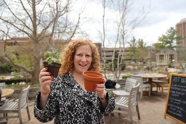 UW-Madison Chancellor Jennifer Mnookin showing a plant and pot from a plant swap at Earth Fest.